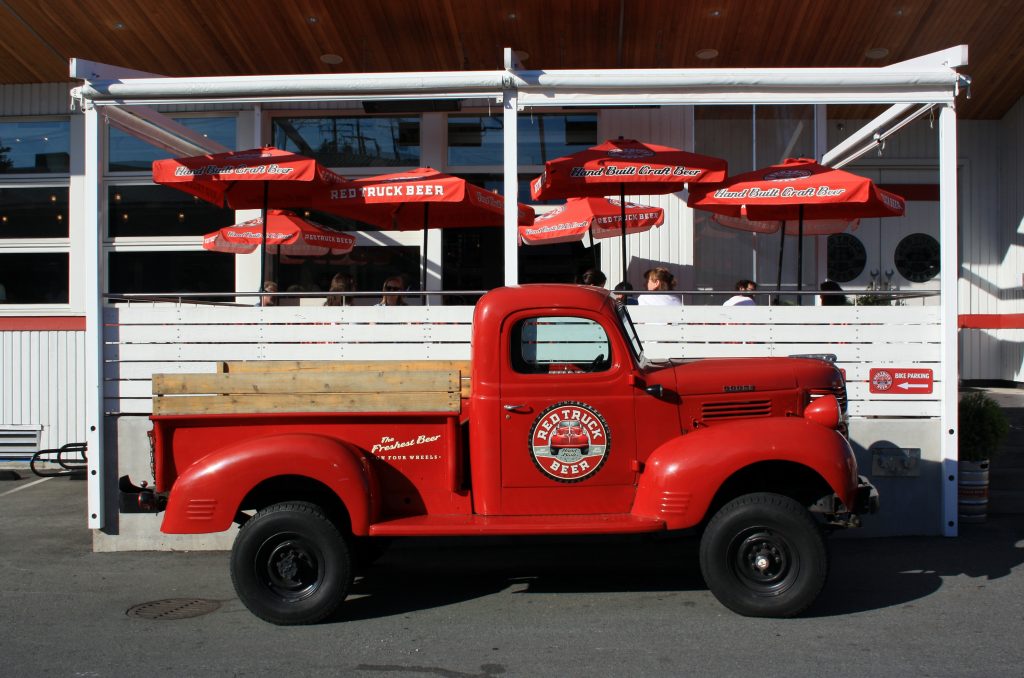 Retro pickup truck in Red Truck Beer livery outside brewery in False Creek Flats, Vancouver.
